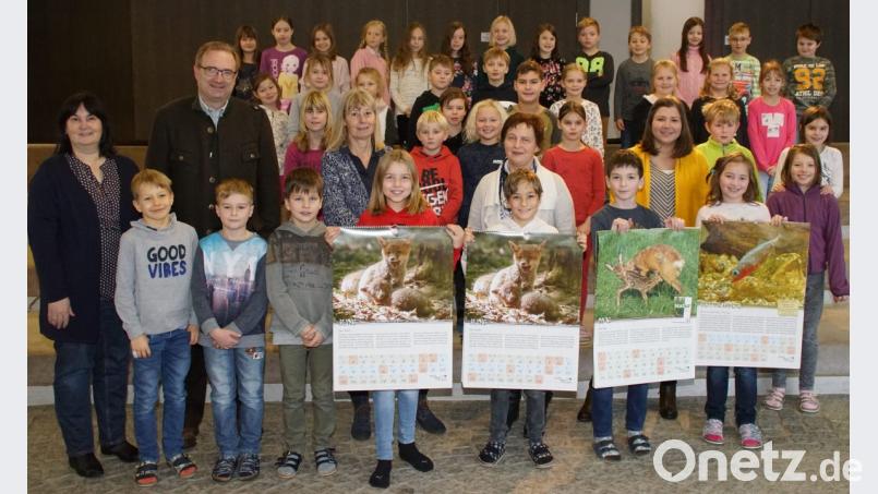 BJV-Kreisgruppenvorsitzender Alexander Flierl übergab den Kalender in Anwesenheit von Bürgermeisterin Birgit Höcherl (links) an Rektorin Maria Pfistermeister (Mitte), die Lehrerinnen Christine Forster und Theresa Reiter und die Kinder der dritten und vierten Klasse. Bild: mmj