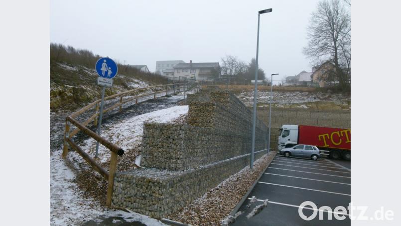 Zum Abschluss der Arbeiten am Edeka-Markt bringen Mitarbeiter des Bauhofs am Verbindungsweg zwischen Markt und Gerhart-Hauptmann-Straße ein Geländer an. Bild: rn