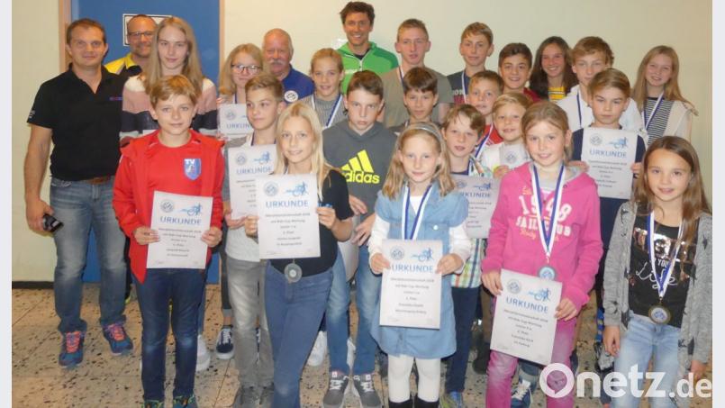 Die erfolgreichen Sportler bei der Siegerehrung des Kids-Cups 2018 in Kümmersbruck mit den Jugendleitern des BTV-Bezirks Oberpfalz, Harald Kaunz (links) und Christian Betzlbacher (rechts daneben), dem Vorsitzenden des BTV-Bezirks Oberpfalz, Gerd Rucker (hinten, Fünfter von links), und Profi-Triathlet Sebastian Neef (rechts daneben). Bild: Heiko Schneider