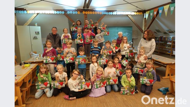 Große vorweihnachtliche Freude beim Bastelnachmittag der Siedlergemeinschaft und der Freien Wähler. Stolz präsentieren die Kinder am Ende ihr weihnachtliches Kunstwerk. Oskar Schuster (hinten links), Elfi Kempke (hinten rechts) und Zita Schuster unterstützten bei der Fertigung die Kinder und hatten dabei viel Spaß und Freude. Bild: bsc