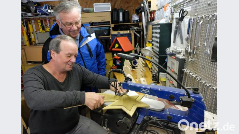 Handwerkliches Geschick zeigt der Flosser Peter Späth (vorne) beim Aufbau der Volkskrippe. Er fertigt die Kulissen für die drei neuen Darstellungen an und bereichert damit das kleine Kunstwerk. Helmut Weig (stehend) dankt Späth für seine künstlerische Arbeit als Spende Bild: le