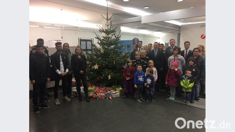 Filialleiter Christian Wolf (hintere Reihe, Fünfter von rechts) übergibt die Geschenke an die Kinder. Bild: exb