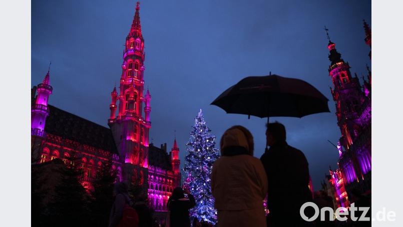Menschen bewundern gemeinsam in Brüssel einen geschmückten Weihnachtsbaum auf dem beleuchteten Grand Place. Bild: Francisco Seco/AP/dpa