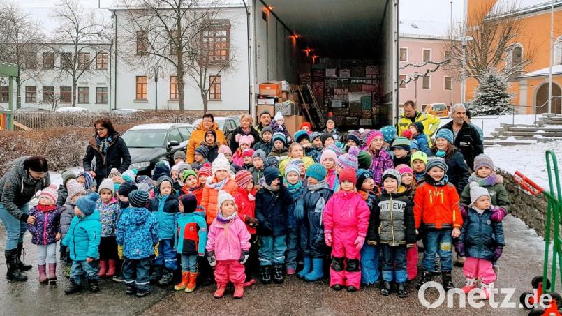 Der Waidhauser Nachwuchs ist Feuer und Flamme für die Weihnachtstrucker-Aktion des Theatervereins und hilft den LKW-Fahrern Ludwig Wüst und Christian Fuchs (hinten, von rechts) beim Beladen. Bild: fjo