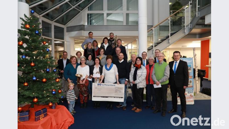 Vorstand Joachim Geyer (rechts), Geschäftsstellenleiter Hans Dumler (dritter von rechts) und Kundenberaterin Doris Thurm (erste Reihe vierte von links) überreichen 5000 Euro an die Vertreter der Vereine. Bild: njn