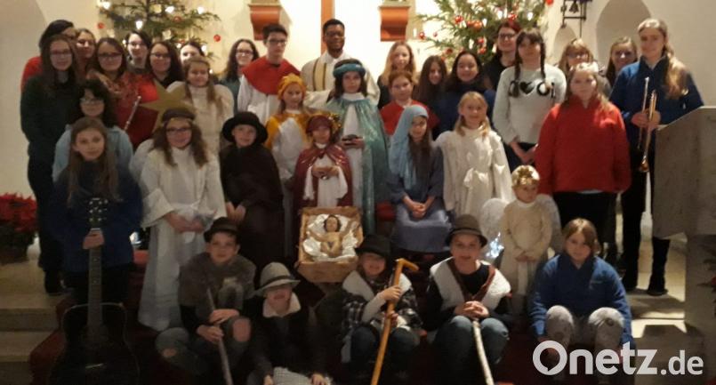 Im Mittelpunkt der kleinen Andacht an Heiligabend steht natürlich das Jesukind in der Krippe. Rund 40 Kinder und Jugendliche gestalten mit Pfarrvikar Justin Kishimbe den Wortgottesdienst in der voll besetzten Herz-Jesu-Pfarrkirche. Bild: mez