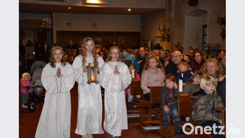 Die drei Engel Katharina Kellermann, Luzia und Katharina Stefinger (von links) tragen das Friedenslicht zum Altar. Bild: gi