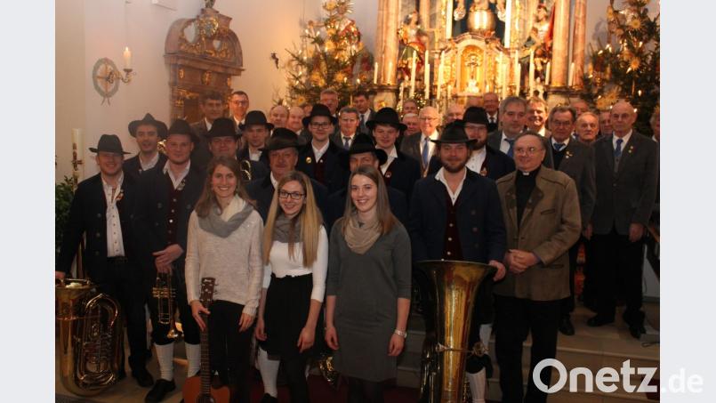 Beim Adventssingen in der Pfarrkirche St. Vitus Utzenhofen wirken mit: „II Coretto Utzenhofen (vorne), ein Blechbläserensemble der Trachtenkapelle Hohenburg (stehend) und der MGV Kastl-Schwend (hinten) sowie Pfarrer Josef Kanovsky (zweite Reihe, rechts) und Leiter Wolfgang Herdegen. Bild: aun