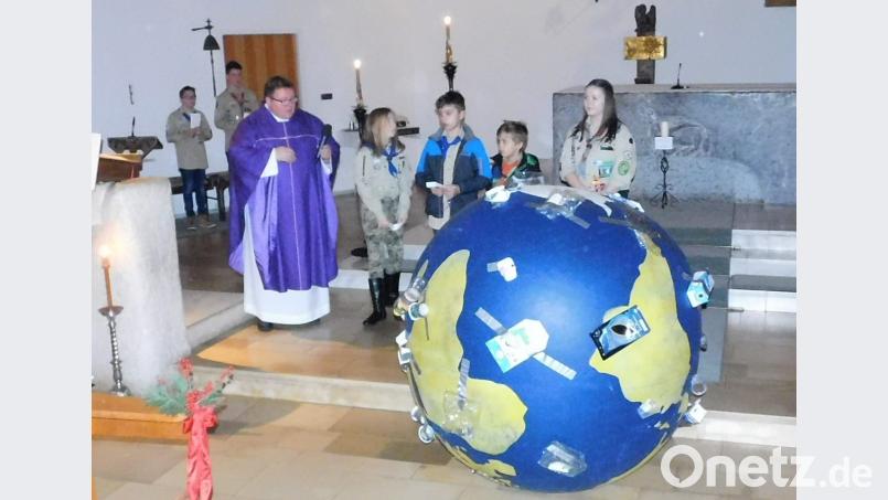 Die Pfadfinder rufen im Gottesdienst zu Nachhaltigkeit auf. Dazu haben sie einen überdimensionierten vermüllten Erdball mitgebracht. Bild: hai