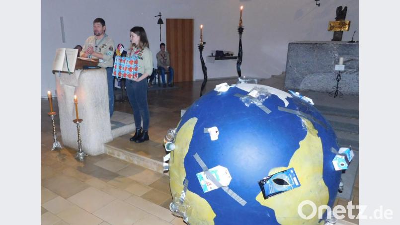 Die Pfadfinder rufen im Gottesdienst zu Nachhaltigkeit auf. Dazu haben sie einen überdimensionierten vermüllten Erdball mitgebracht. Bild: hai