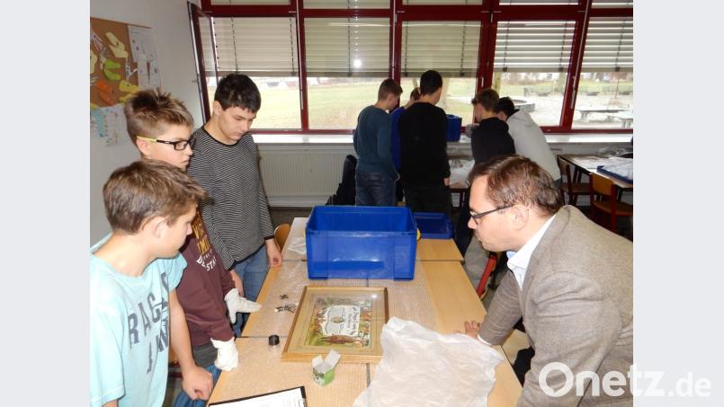 Nur mit Handschuhen dürfen die Schüler die Museumsstücke anfassen. Bild: exb