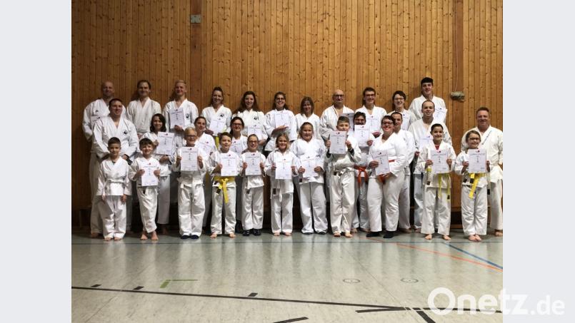 Die Karateka freuen sich mit Ausbilder Jürgen Kraus (rechts) über die bestandene Prüfung. Bild: fz