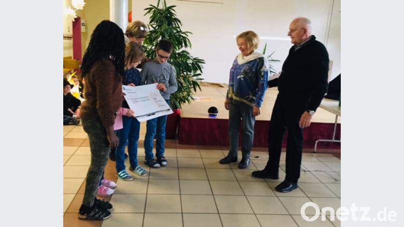 Die Kinder der Hammerweg-Grundschule übergeben einen Spendenscheck für das &quot;Giriama-Projekt&quot;. Bild: exb