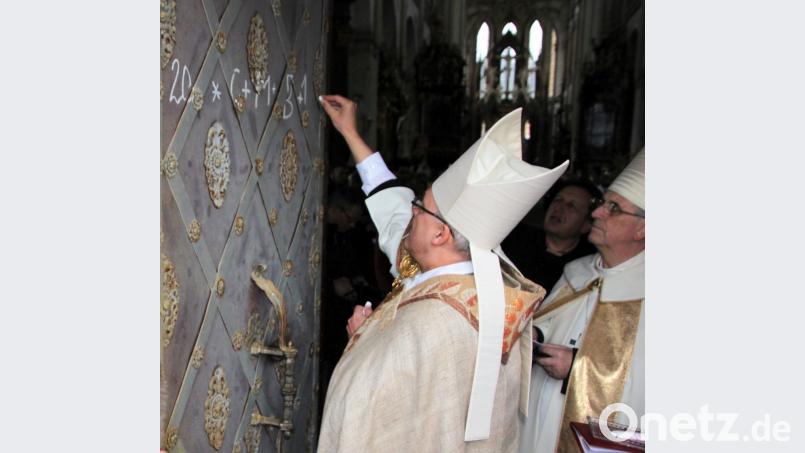 Der Regensburger Bischof Rudolf Voderholzer schreibt den Dreikönigssegen auf die Eingangstür zur Basilika in Kladruby/Kladrau. Archivbild: cr