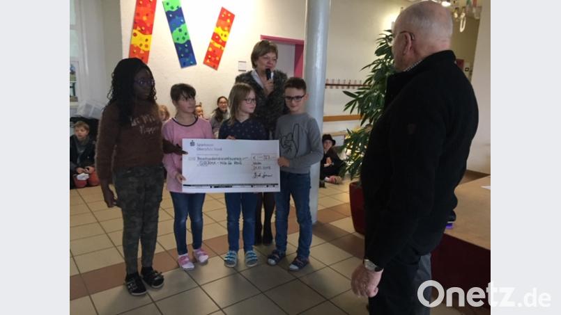 Die Kinder der Hammerweg-Grundschule übergeben einen Spendenscheck für das &quot;Giriama-Projekt&quot;. Bild: exb