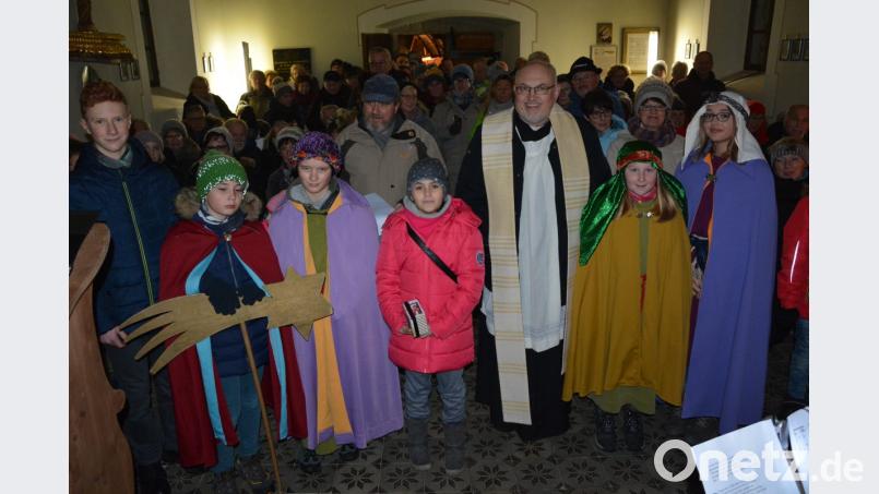 So viele Besucher (Hintergrund) wie noch nie nahmen an der Wanderung zur Andacht in der Gommelbergkapelle auf dem Hausberg der Pleußener teil. Stadtpfarrer Anton Witt und die Sternsinger begrüßten die Wanderer. Bild: jr