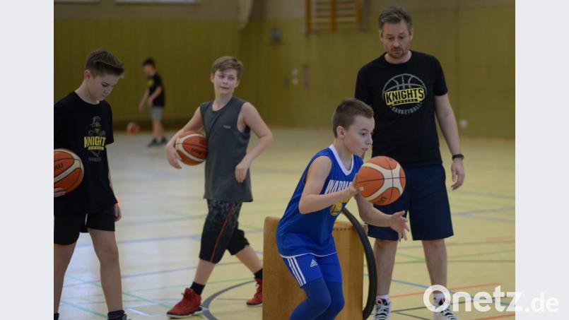 Trainer Michael Holtschulte (rechts) bringt den Kids Basketball bei. Bild: ref