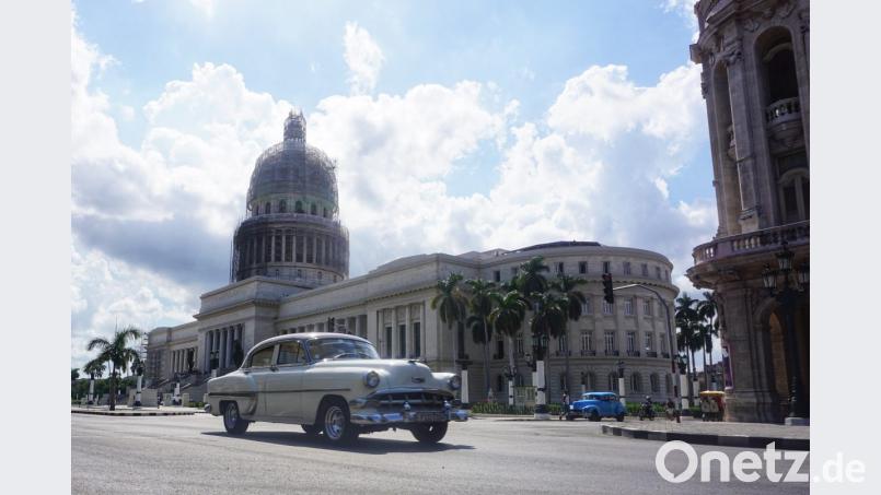 Ein weißer Chevrolet rollt über eine Straße von Havanna. Im Hintergrund steht das berühmte Capitolio, das zwei Meter höher ist wie das Vorbild in Washington. Bild: jut