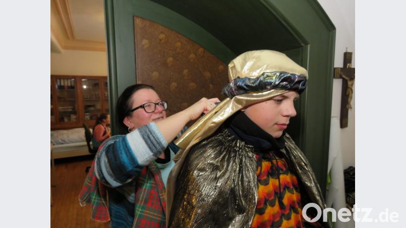 Martina Würl hilft Jonas beim Befestigen des Turbans. Bild: ubb