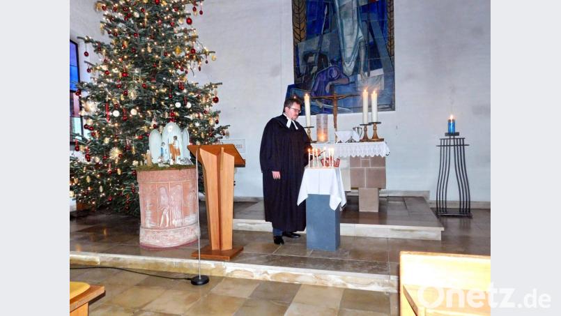 Pfarrer Micha Boerschmann entzündet sieben Kerzen, jede von ihnen „für Vieles, was war, was hinter mir, hinter uns liegt“, wie der Geistliche erklärt. Bild: hai