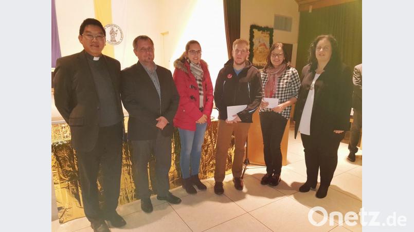 Mit Spendenkuverts warten Magdalena Maul und Felix Schraml von der Katholischen Landjugend sowie Angela Kummert-Schleicher (Dritte bis Fünfte von links) im Namen des Kirchenchores beim Neujahrsempfang der Pfarrei auf. Pater Samuel Patton und Kirchenpfleger Georg Schraml (von links) sowie Sonja Schwemmer (rechts) vom Pfarrgemeinderat sind hocherfreut über die insgesamt 1500 Euro. Bild: hzi