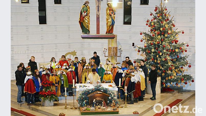 Bei ihrer Aussendung und Segnung durch Pfarrer Augustin Lobo scharen sich die Sternsinger in ihren bunten Gewändern um den Altar der Pfarrkirche. Bild: ü