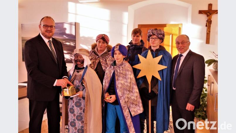 Landrat Andreas Meier (links) spendet für die Sternsinger, Albert Nickl (rechts) überreicht Naschereien. Bild: arw