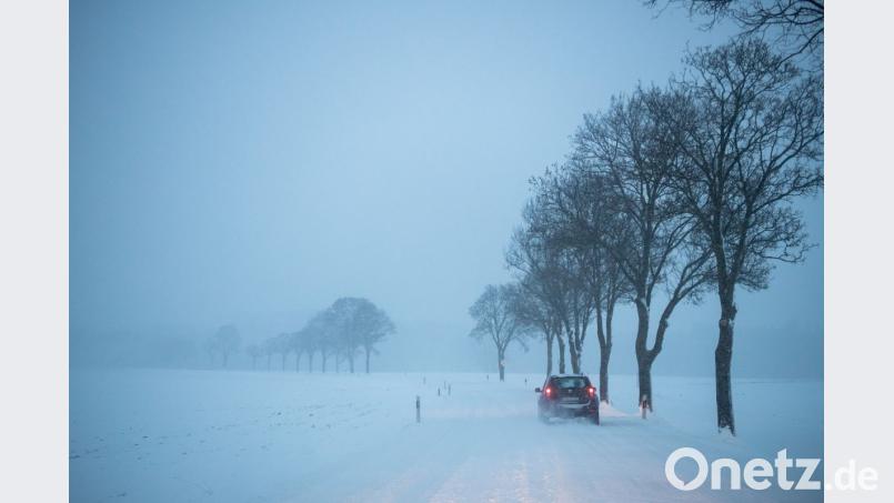 Ein Auto auf einer verschneiten Landstraße bei Hohenlinden in Bayern. Bild: Lino Mirgeler