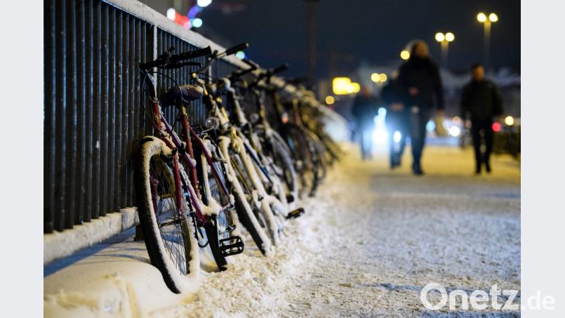 Verschneite Fahrräder auf einer Brücke in München. Bild: Matthias Balk