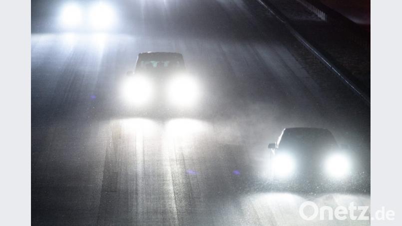Autos fahren über die verschneite Autobahn 8 bei Sauerlach. Bild: Matthias Balk