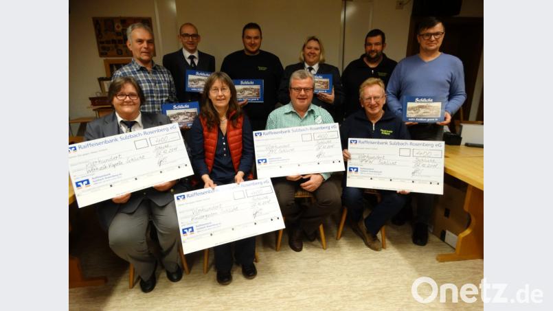 Über die Spende der Schlichter Chronik-Verfasser Peter Wismeth (links) und Stefan Weiß (rechts) freuen sich (sitzend von linka) Anja Schertl (WVK), Monika Krieger (Kita), Ewald Vater (FCS) und Herbert Wiesnet (FFW). Bild: ct