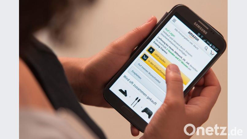 Eine Frau bedient die Smartphone-App des Onlinehändlers Amazon. Bild: Sebastian Gollnow/dpa