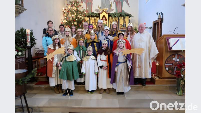 Seelsorger Siegfried Wölfel (rechts) feiert am Fest Heilige Drei Könige zusammen mit den Sternsingern einen festlichen Gottesdienst. Der Geistliche würdigt dabei die breite Unterstützung durch die Eltern und die Organisatoren Christine Klöble, Andrea Schraml (hinten von links) sowie Alexandra Kaßeckert (mittlere Reihe, links). Bild: bsc