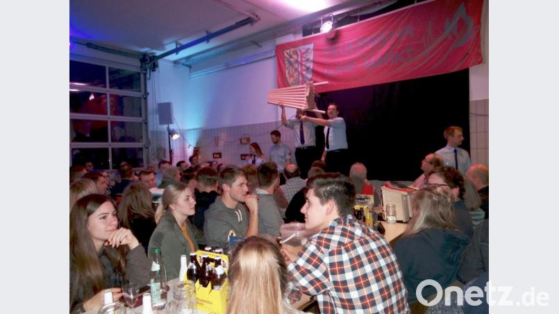 Mit viel Engagement bringen die Feuerwehrleute die Waren an die Käufer und treiben die Preise in die Höhe. Bild: mld