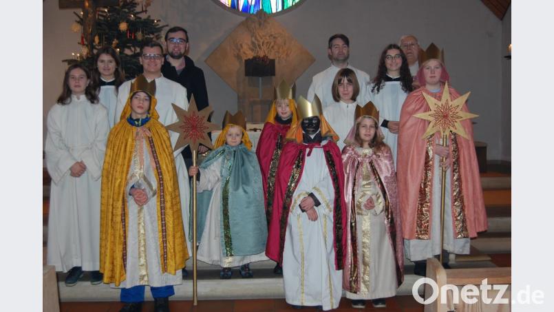 Die Sternsinger erhalten in ihren prächtigen Gewändern den Segen des Priesters. Bild: az