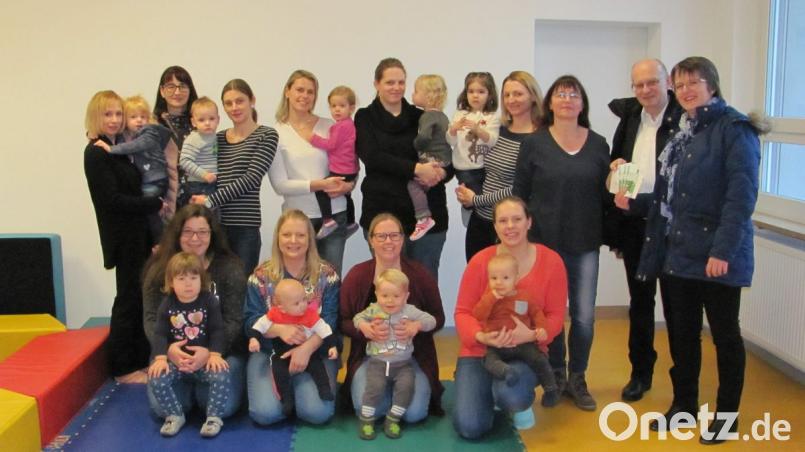 Daniela Fuhrmann (hinten, rechts), Manfred Klier (hinten, Zweiter von rechts) und Andrea Bertelshofer (hinten, Dritte von links) überreichen an Claudia Bertelshofer (hinten, Dritte von rechts) 300 Euro für die Eltern-Kind-Gruppen. Bild: sei