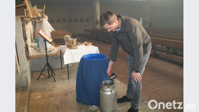 Lucas Reichenberger schöpft das Dreikönigs-Weihwasser nach dem Festgottesdienst in Waldershof in die dafür vorgesehene Milchkanne. Bild: fpoz