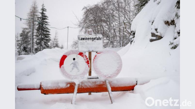 Ein Schild weist an einer Wegsperre am Spitzingsee auf eine Lawinengefahr hin. Bild: Lino Mirgeler/dpa
