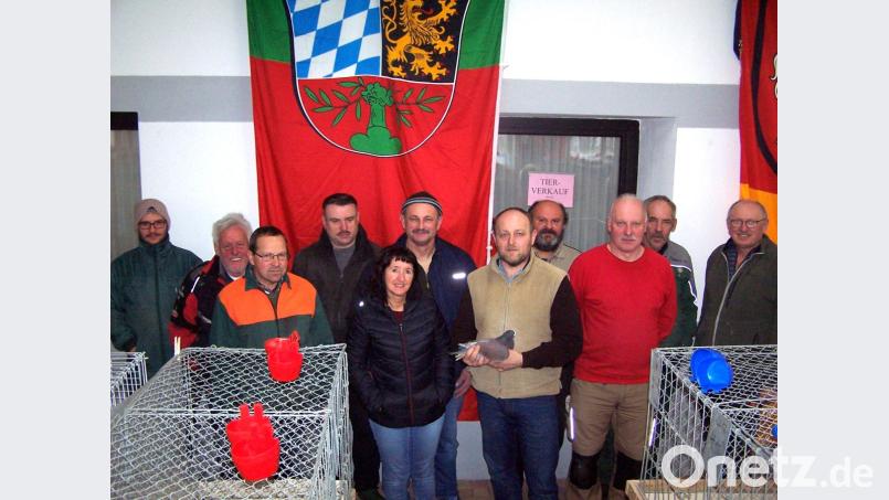 Ausstellungsleiter Sigi Rupp (mit Taube) aus Eslarn dankt seinem großen Helferteam für den mehrere Tage dauernden Aufbau der Sonderschau. Bild: fjo