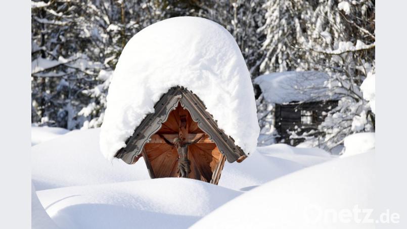 Schnee bedeckt eine Christusfigur. Foto: Tobias Hase/Archiv Bild: Tobias Hase