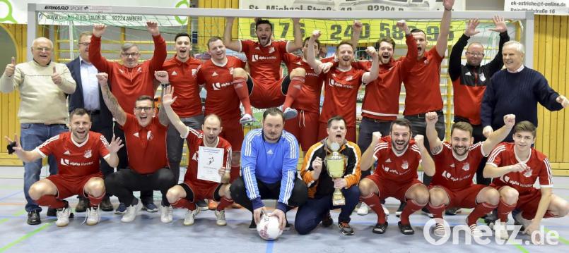 Ein jubelnder Stadtmeister SV Inter Bergsteig Amberg. Torhüter Christopher Hahn (vorne, blaues Ttrikot) wurde zudem noch zum besten Torhüter des Turniers gewählt. Mit der Mannschaft freuen sich Inter-Vorsitzender Georg Carlejan (links), Bürgermeister Martin Preuß (rechts daneben), Norbert Fischer, Stadtverbandsvorsitzender für Sport (rechts) und Inter-Trainer Markus Kipry (Zweiter von rechts). Bild: Hubert Ziegler