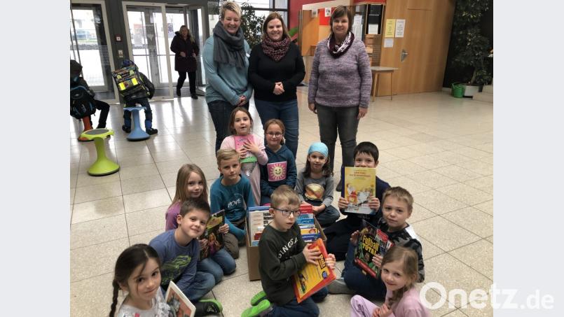 Katharina Stümpfl und Yvonne Först vom Organisationsteam des Schnaittenbacher Spielzeugbasars übergeben an Sabine Weiß (von links) als Ansprechpartnerin der Schulbücherei nicht nur neues Lesefutter, sondern auch eine Spende in Höhe von 280 Euro. Bild: ads