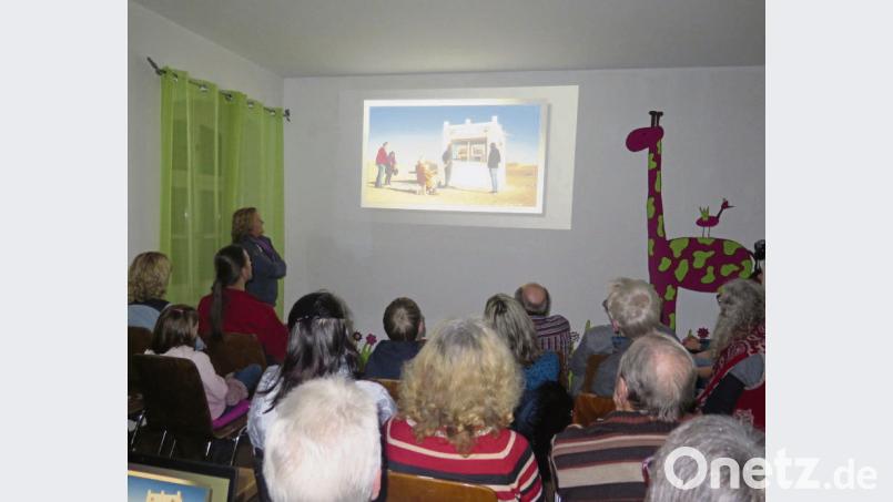 „Das Sahara-Kunstkasterl von Günter Haslbeck soll Menschen sensibilisieren, nachhaltig und schützend mit der Natur umzugehen“, erklärt Monika Diefenbach (vorne links) bei ihrer Slideshow über Marokko. Bild: jzk