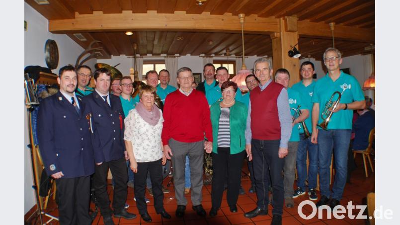 Jubilar Walter Pompl (Mitte) zusammen mit (von links) Kommandant Norbert Scharnagl und Vorstand Florian Dietl von der Feuerwehr Ottengrün, Ehefrau Hildegard, Zwillingsschwester Sieglinde Kaiser mit Ehemann Franz sowie die Musiker der Blaskapelle Ernestgrün. Bild: enz