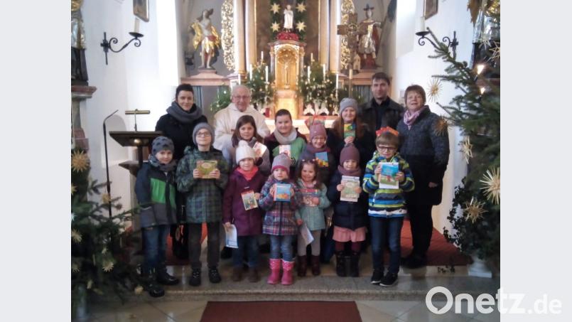 Die Kinder mit den Bilder-Gebetsbüchern zusammen mit Pater Friedhelm Czinczoll sowie Sylvia Hausner (links) und von rechts Ulrike Kraus und Jörg Wifling. Bild: exb
