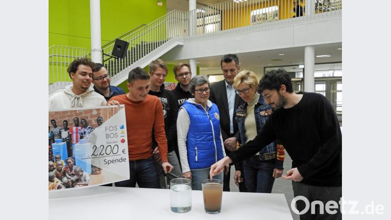 Bei der Scheckübergabe erklärt Constantin Vogel (rechts) vom Studentenverein „Hydro Solution“, wie der Filter aus schmutzigem Wasser sauberes macht. Für die großzügige Spende dankte er der Schulfamilie der FOS/BOS. Bild: Winkler