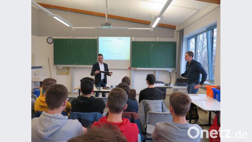 Werkzeugmechanikermeister Jörg Zechmayer und Ausbildungsleiter Andreas Fahrnbauer (von links) aus Grafenwöhr zeigen den Neuntklässlern, welche Teile ihre Zuliefererfirma für die Innenverkleidung von bestimmten Autotypen herstellt. Bild: jzk
