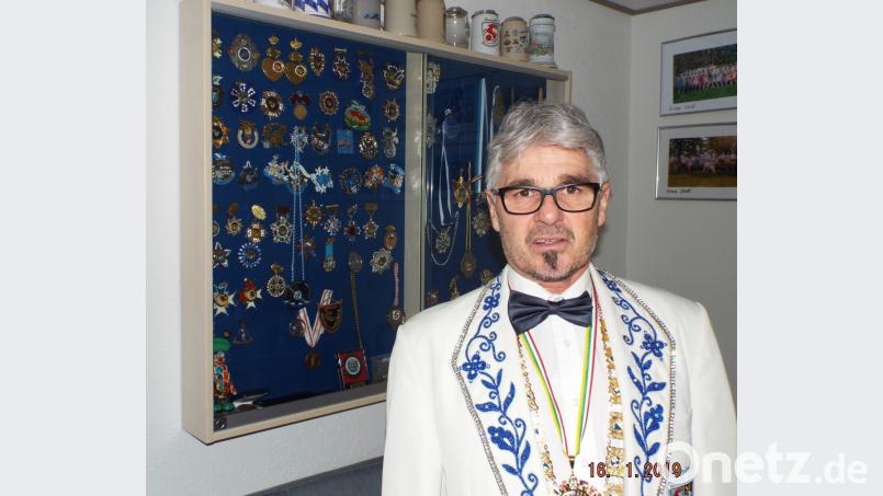 Streber heute vor Glasvitrine mit Ehrenzeichen des eigenen Vereins, die er &quot;kistenweise&quot; hat Bild: e