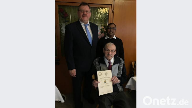 Bürgermeister Hans-Martin Schertl und Pfarrvikar Madanu (hinten, von links) überbringen Alfred Kredler die Glückwünsche zum 80. Geburtstag. Bild: Stefanie Gradl