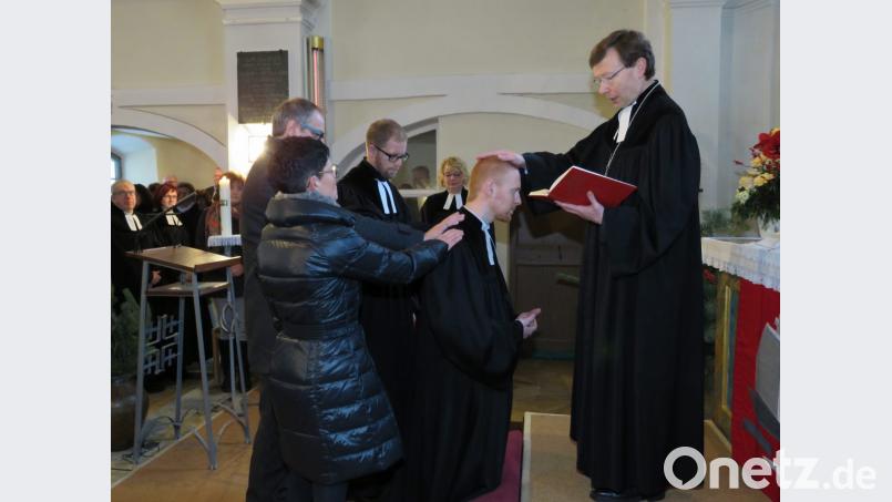 Dekan Wendrich Slencka (rechts) segnete Pfarrer Christoph Zeh (im Bild knieend) und Pfarrerin Nadine Schneider zur Amtseinführung feierlich. Ausgewählte Pfarrvorstände (links) sprachen dazu Segenswünsche. Bild: ubb